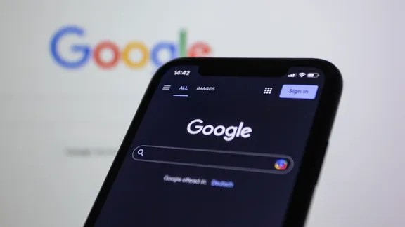 A phone in hand with Google search open