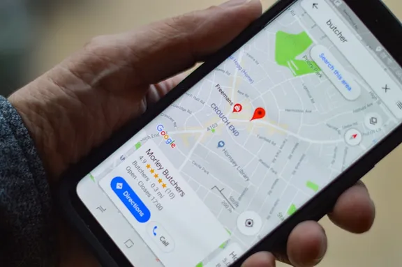 A phone showing a local business pinned on the map with a call button